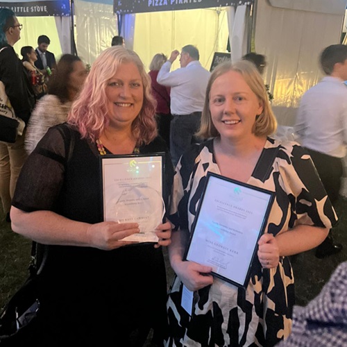 Katy Lambert and Georgie Kerr holding their staff Excellence Award