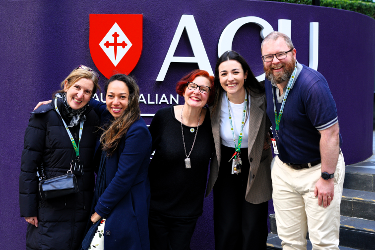 Trevor Ianna and ANU colleagues standing in front of ACU banner