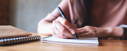 Person sitting at a desk writing