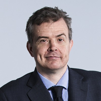 Head shot of Ben Gauntlett wearing a dark gray suit and tie