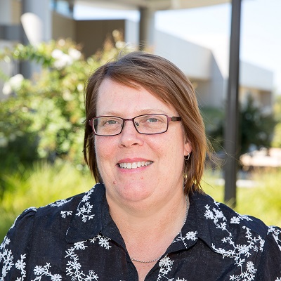 Headshot of Sandra Boyd wearing a black shirt with white flowers